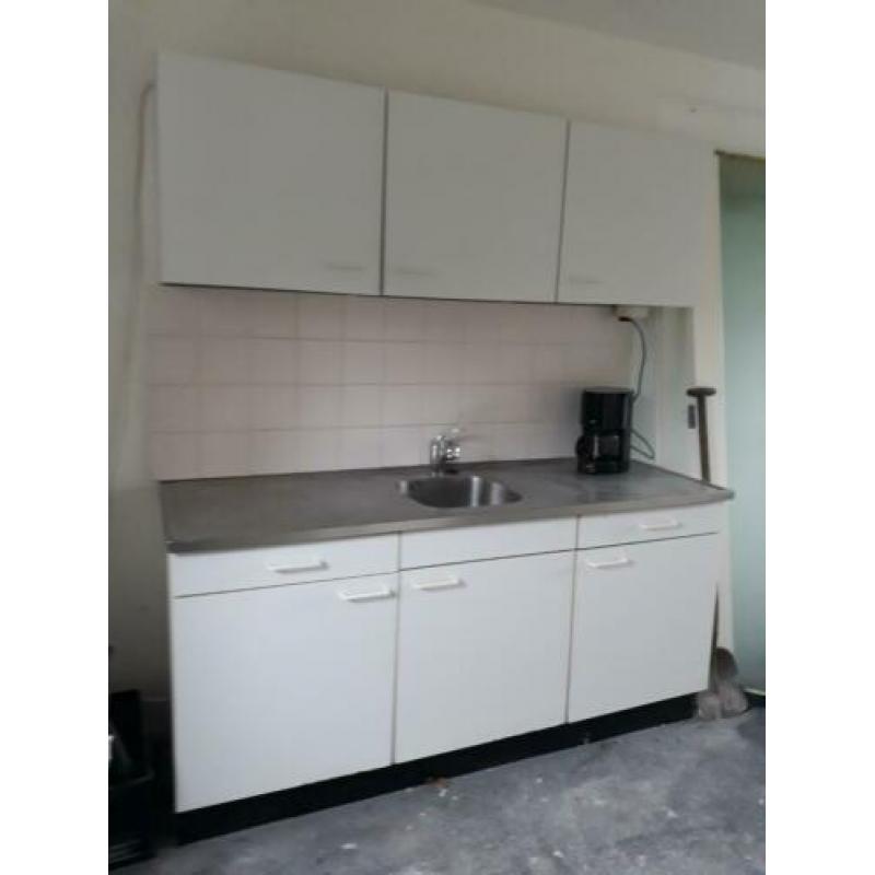 Eenvoudige witte keuken met boiler en uittrekbare kraan.