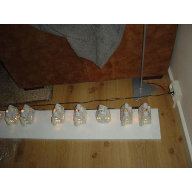 kerstdorp met verlichting op houten plank